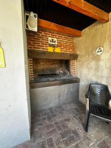a brick fireplace in a room with a chair at El descanso in Ramallo