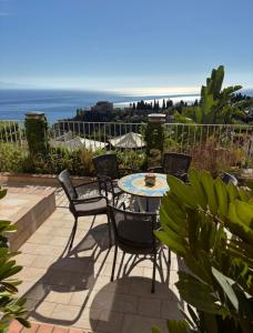 a patio with a table and chairs and the ocean at Taormina Sunrise in Taormina
