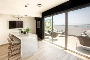 a kitchen and living room with a large window at Barranco Modern Apartments with Rooftop Pool by Geko in Lima