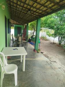 a white table and chairs on a porch at Recanto Dunas Santa Rita in Estância +2 photos