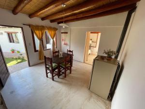 a living room with a table and chairs and a door at Balcones del Pintor in Maimará