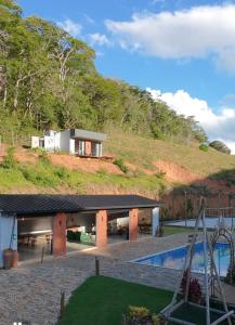 a house on top of a hill with a swimming pool at Chalé São Bernardo, Carmo RJ in Carmo
