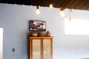 a room with a wooden cabinet with lights on the wall at Chalé São Bernardo, Carmo RJ in Carmo