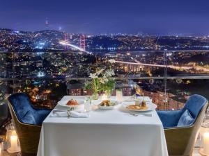 a table with plates of food on it with a view at Raffles Istanbul in Istanbul