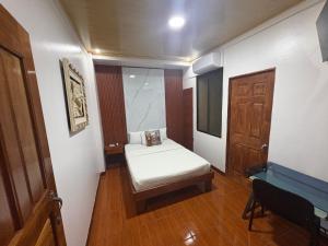 a small room with a bed and a door at Hotel Wilson Ciudad Neily in Neily