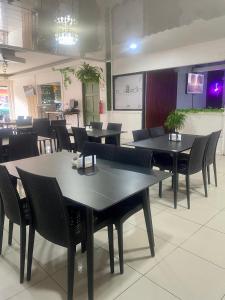 a dining room with tables and chairs in a restaurant at Hotel Wilson Ciudad Neily in Neily