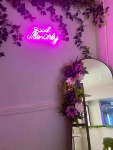a neon sign that says good vibes on a wall at Hotel Wilson Ciudad Neily in Neily