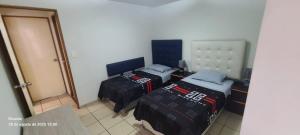 a room with two beds in a room with a door at Departamento Centenario in Lima