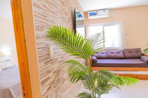 a living room with a couch against a brick wall at Departamentos Valle de los Andes in San Rafael +25 photos