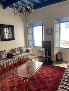 a living room with a couch and a glass table at Meryem Appartement in Essaouira