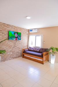a couch in a room with a tv on a brick wall at Departamentos Valle de los Andes in San Rafael