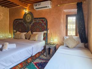a bedroom with two beds and a window at Riad Fes Hayat - Confort Stay in Fez