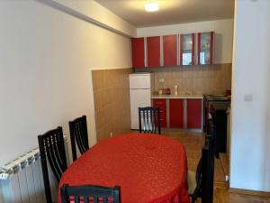 a kitchen with a red table with chairs and a refrigerator at Kolasin Rent Apartment in Kolašin +4 photos