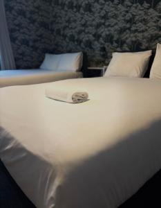 a white bed with a towel on top of it at Piccolo in Glasgow