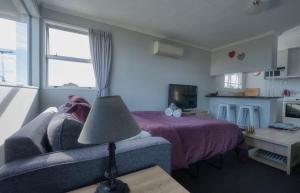 a living room with a couch and a bed at Delight On Dalton in Hokitika