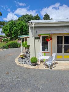 a building with a table and chairs in front of it at Fieldview Arapuni B&B in Putaruru