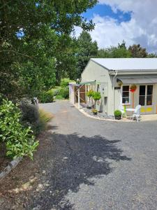a small white building with a bench in front of it at Fieldview Arapuni B&B in Putaruru +18 photos