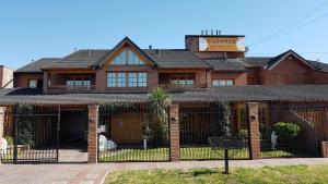 a brick house with a fence in front of it at Colorina Complejo Residencial in San Rafael