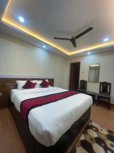 a bedroom with a large bed with a ceiling fan at New milan guest house in Kathmandu