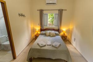 a small bedroom with a bed and a toilet at Pousada Morada do Paraíso in Torrinha