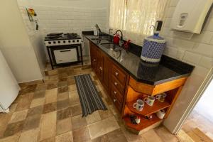 a kitchen with a sink and a stove at Pousada Morada do Paraíso in Torrinha