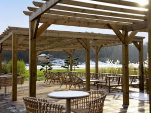 a wooden pergola with tables and chairs on a deck at Ibis Styles Le Touquet in Le Touquet-Paris-Plage