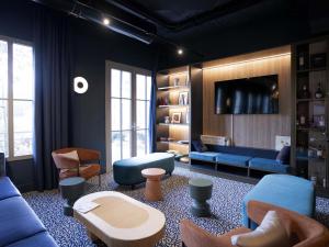 a living room with a blue couch and chairs at Ibis Styles Le Touquet in Le Touquet-Paris-Plage