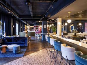 a restaurant with a bar with chairs and tables at Ibis Styles Le Touquet in Le Touquet-Paris-Plage