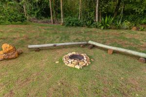 a pile of logs laying on the grass at Pousada Morada do Paraíso in Torrinha