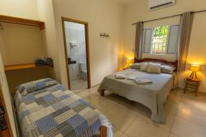 a bedroom with two beds and a bathroom at Pousada Morada do Paraíso in Torrinha +45 photos