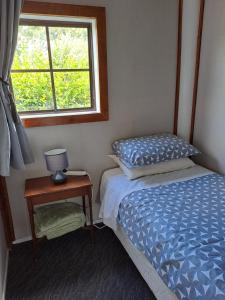 a small bedroom with a bed and a window at Fieldview Arapuni B&B in Putaruru