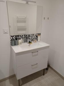 a white bathroom with a sink and a mirror at Le Doudou, Charmant T2 avec Terrasse et Climatisation in Marmande +29 photos