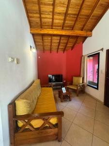 a living room with a couch and a tv at Cabaña La Pinta in Santa Teresita