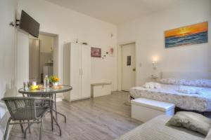 a room with two beds and a table in it at Monolocale City Station in Brindisi