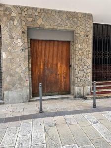 a large wooden door on a stone building at Monolocale City Station in Brindisi