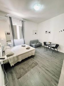 a bedroom with a bed and a couch and a table at Monolocale City Station in Brindisi