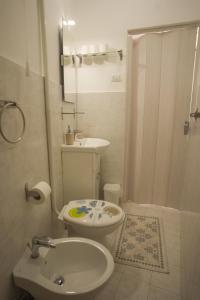 a bathroom with a white toilet and a sink at Monolocale City Station in Brindisi +3 photos