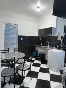 a kitchen with a black and white checkered floor at Residencial Monteiro Luna in Benevides +3 photos
