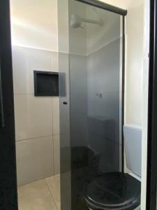 a bathroom with a glass shower with a toilet at Residencial Monteiro Luna in Benevides