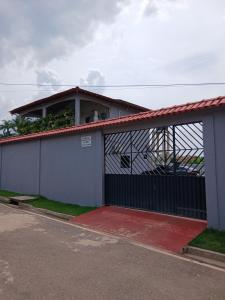 a house with a gate with a red driveway at Residencial Monteiro Luna in Benevides