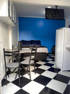 a dining room with a table and chairs and a blue wall at Residencial Monteiro Luna in Benevides