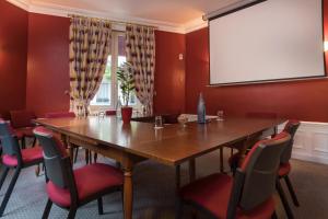 une salle de conférence avec une table, des chaises et un écran de projection dans l'établissement Virgina, à Paris