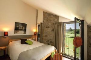 a bedroom with a bed and a large window at ZEcamping 3 étoiles animaux acceptés piscine et Canoë Kayak in Chambonas
