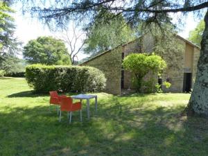 two chairs and a table in the yard of a house at ZEcamping 3 étoiles animaux acceptés piscine et Canoë Kayak in Chambonas