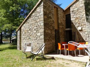 a group of chairs and tables outside of a stone building at ZEcamping 3 étoiles animaux acceptés piscine et Canoë Kayak in Chambonas +15 photos