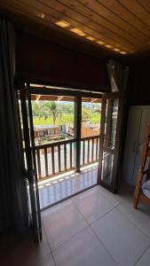 an open door to a balcony with a view at canto da lagoa in Garopaba +8 photos
