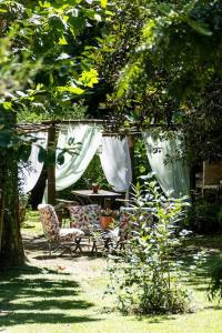 un jardín con mesa y sillas bajo un árbol en Cabaña Los Alcanfores en Tigre