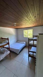 a room with two bunk beds and a wooden ceiling at canto da lagoa in Garopaba