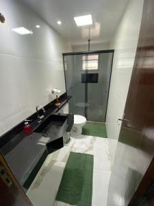 a bathroom with a toilet and a glass shower at Pousada Por do Sol in Teresópolis +24 photos
