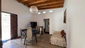 a living room with a table and chairs and a television at LA FACUNDA in San Francisco del Monte de Oro
